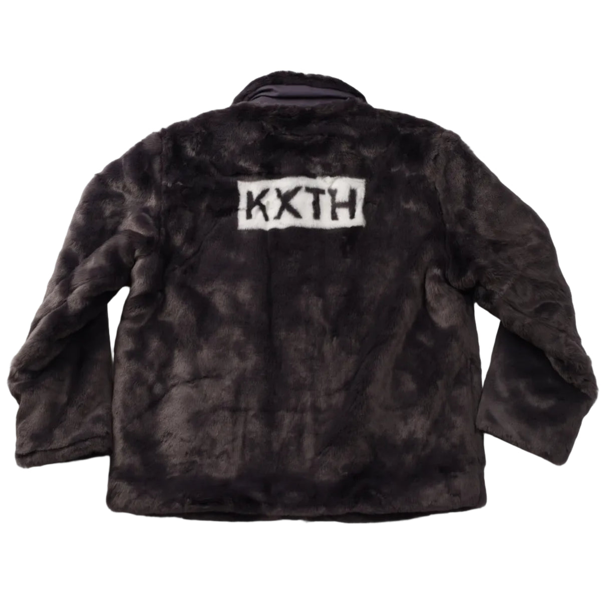 A dark brown and black tie-dye faux fur jacket with a white rectangular patch on the back featuring the black text 'KXTH', laid flat on a white background.